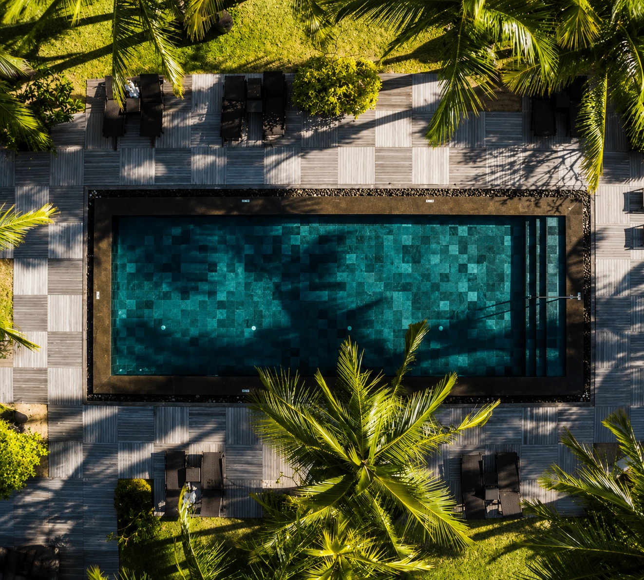 Piscina retangular com revestimento em pedra escura
